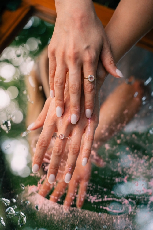 Pierścionek z okrągłym kwarcem różowym z diopsydem na dłoniach modelki